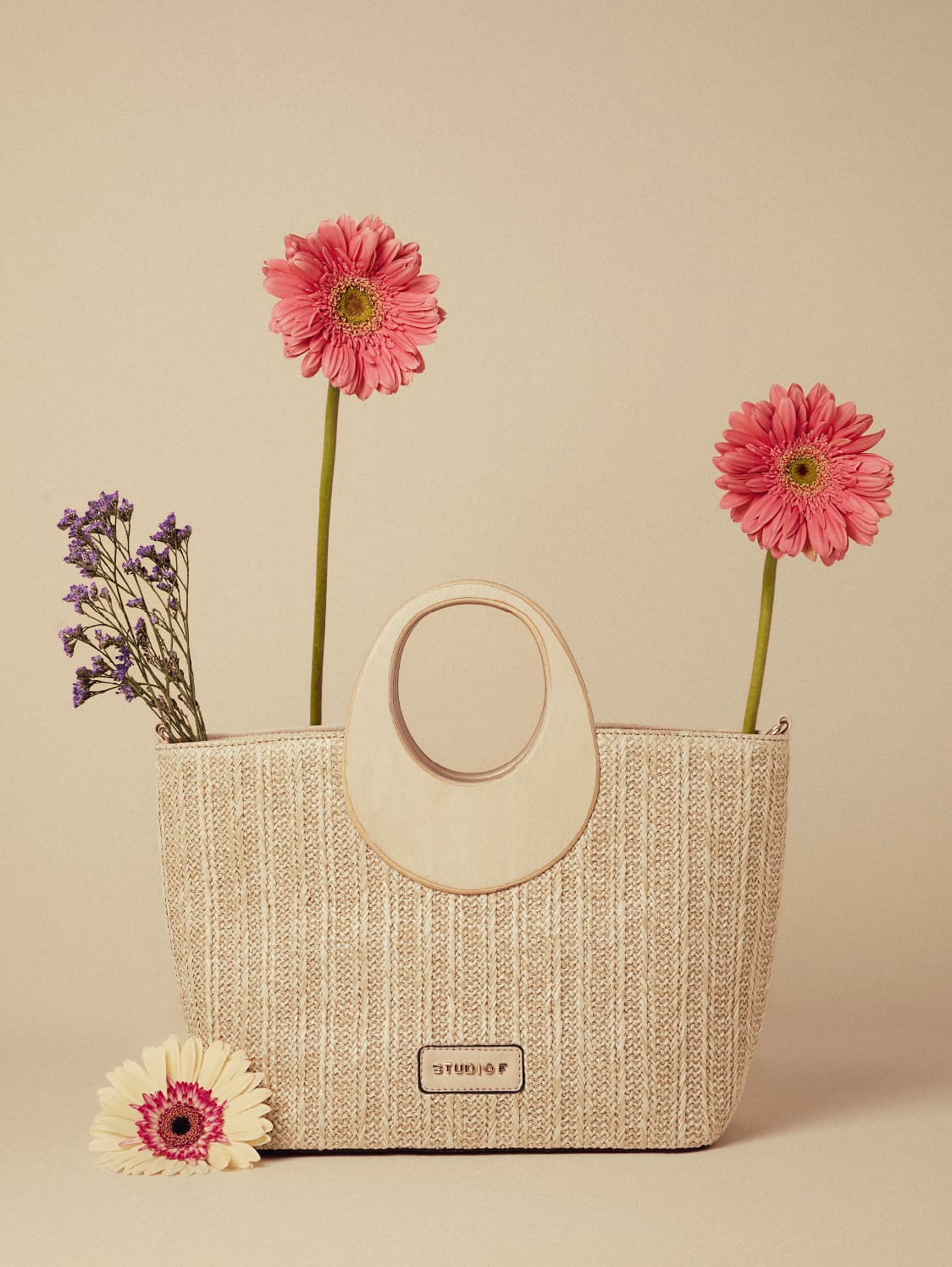 Foto de bolso de mano en fibras naturales con asa de madera con flores dentro de la bolsa