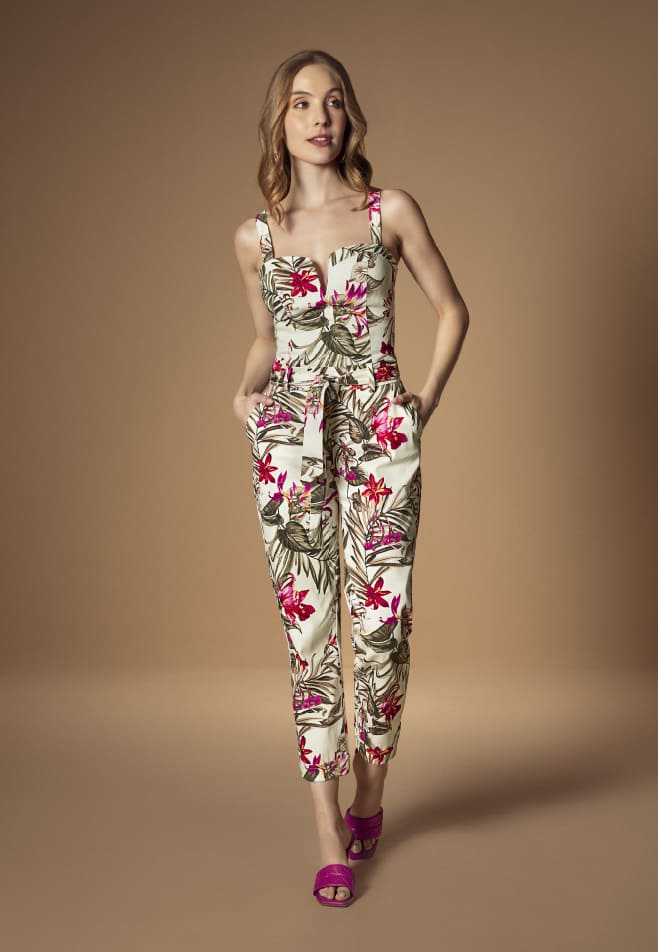 Mujer usando enterizo de estampado floral y sandalias de tacón color fucsia de la nueva colección de Studio F