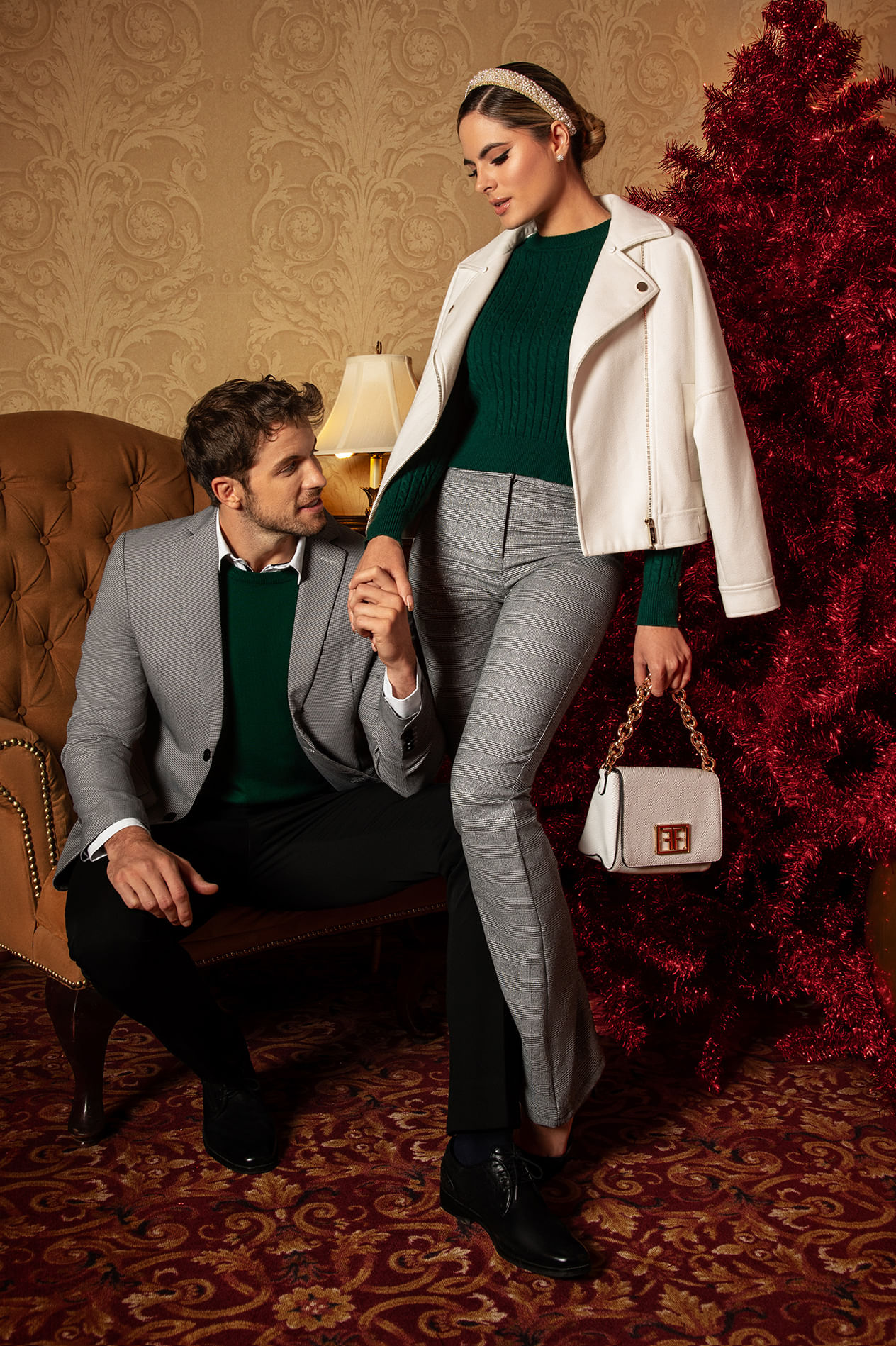 Pareja de hombre y mujer usando look para navidad: blazer blanco, suéter color verde, pantalón gris y bolsa de mano color blanco