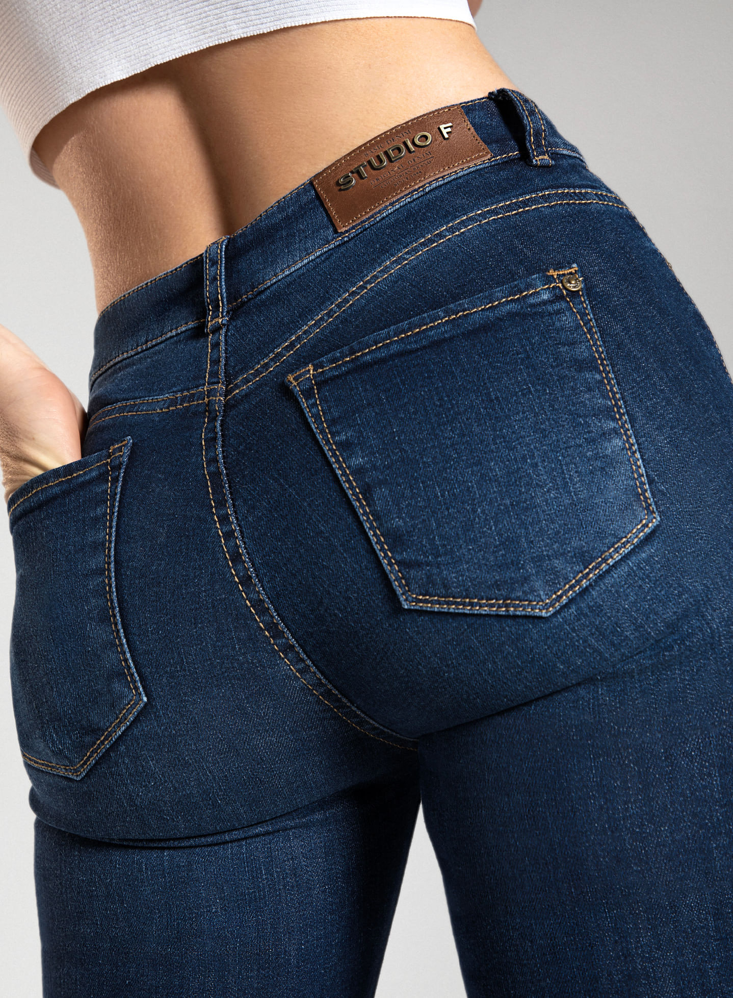 Foto de mujer de espaldas con jean bota campana, con 5 bolsillos, tiro alto y pretina angosta de la marca Studio F 