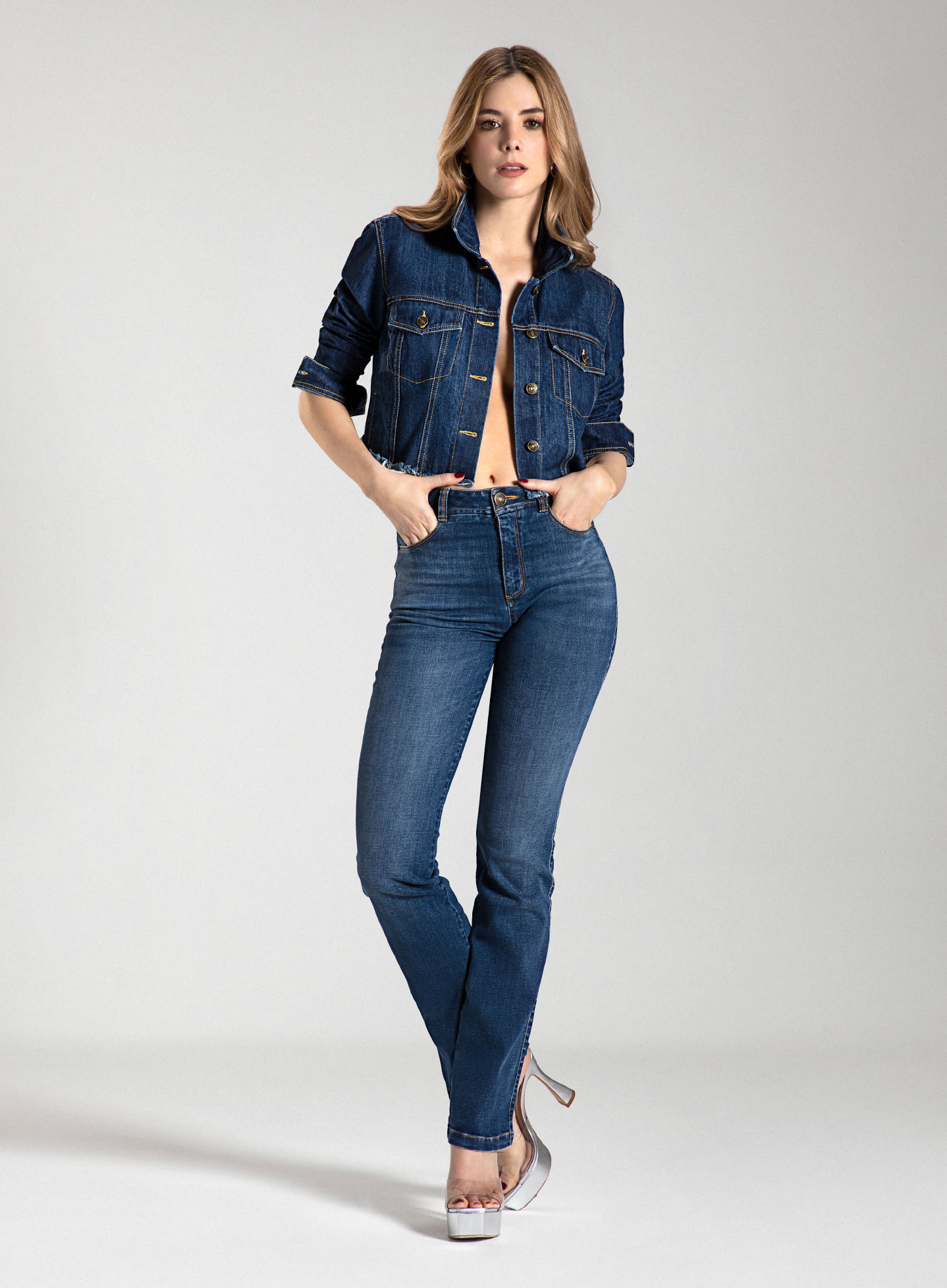 Mujer usando jean bota recta, pretina angosta y tiro alto, chaqueta de jean de la marca Studio F