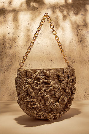 Foto de bolsa de mano en fibras orgánicas color café con cadena dorada de la marca Studio F México