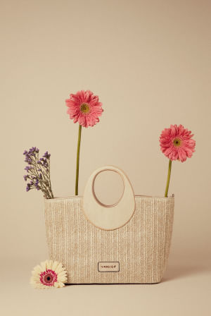 Foto de bolsa de mano para mujer en tono neutro, con yute y asa de madera con flores de colores 