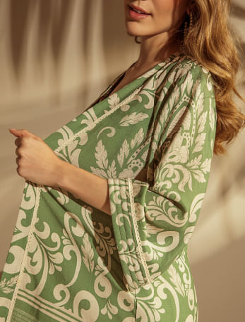 Foto en plano medio de mujer usando sobretodo largo estampado color verde de la marca Studio F