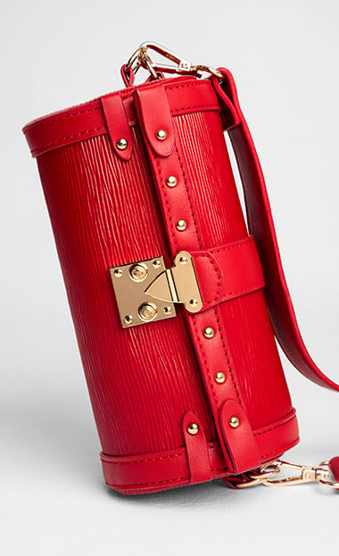 Bolso manos libres para mujer rojo en forma de cilindro  con herraje dorado en fondo blanco de la marca Studio F México