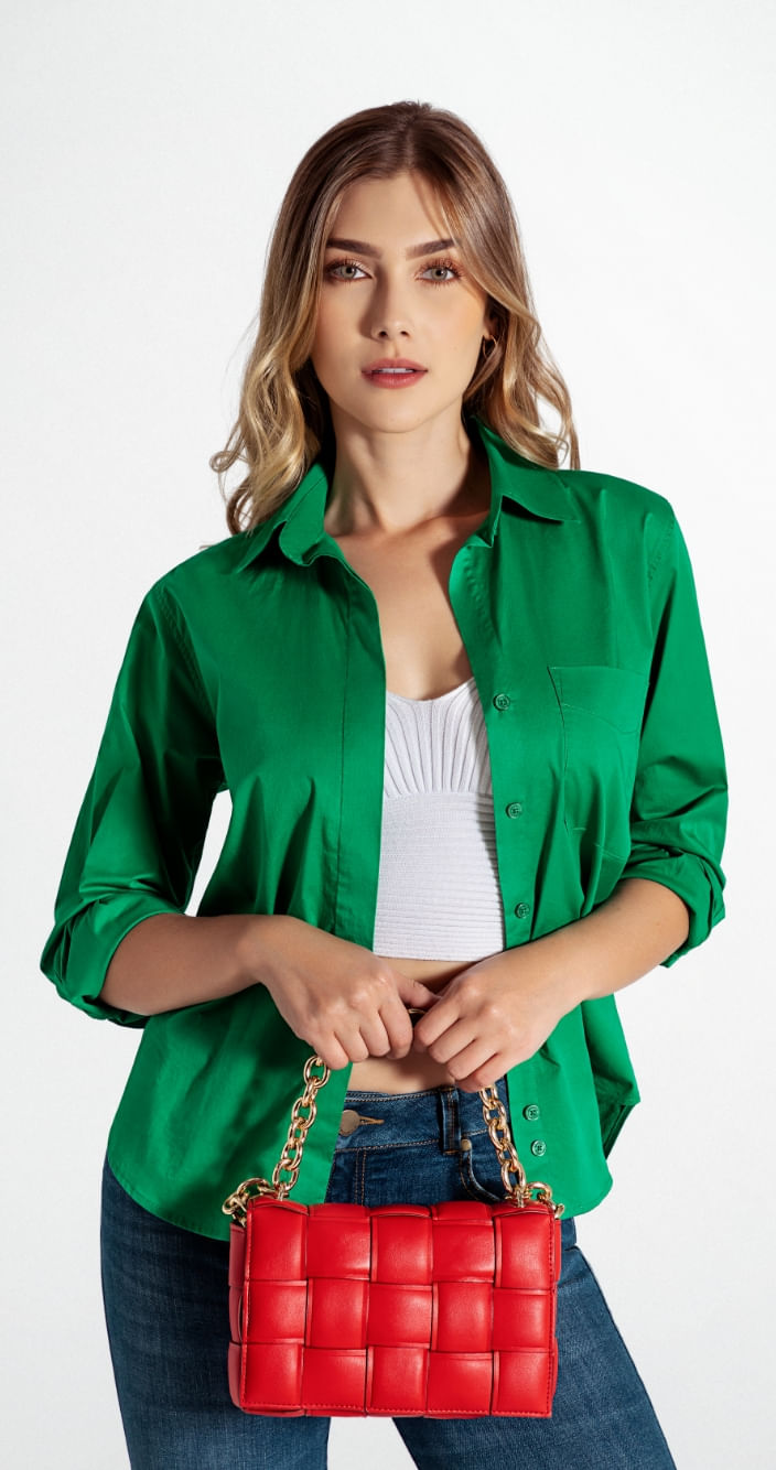 Modelo mujer usando blusa camisera verde, crop top color blanco y bolsa rojo acolchado con cadena dorada como complemento